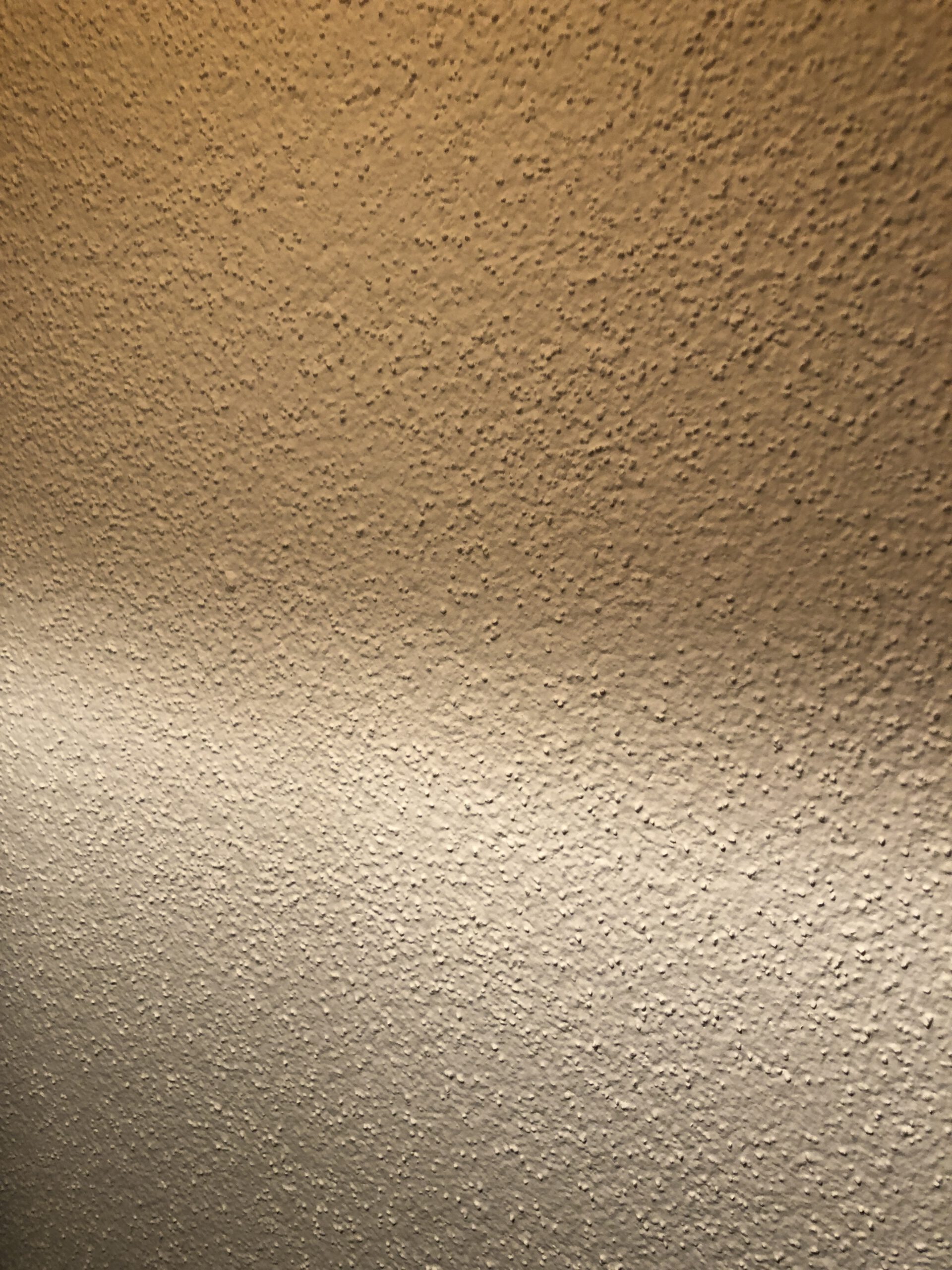 Streiflicht auf einer weiss gestrichenen Raufasertapete